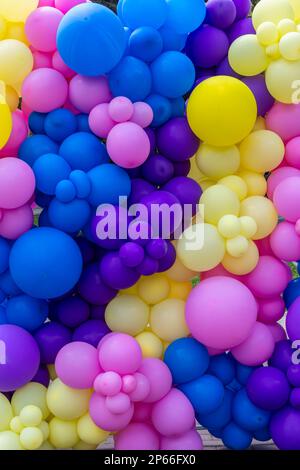 Leuchtender abstrakter Hintergrund mit regenbogenfarbenen Ballons, die feiern. Stockfoto