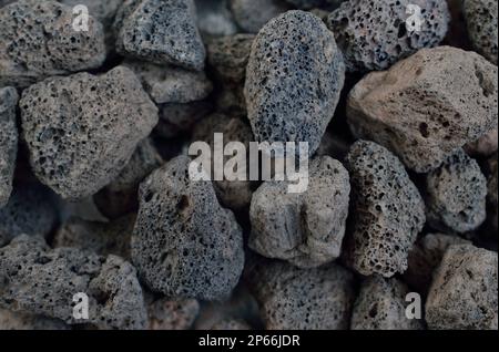 Poröser schwarzer Vulkanstein, isoliert auf weißem Hintergrund. Lavastein, Bimsstein oder vulkanischer Bimsstein mit unverwechselbaren Poren. Stockfoto