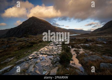 Steinernen Fußweg in Richtung Llyn Ogwen mit Blick auf Tryfan im Snowdonia National Park, Ogwen, Conwy, Wales, Vereinigtes Königreich; Europa Stockfoto
