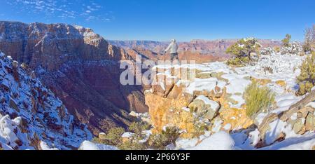 Ein Wanderer, der auf einer verschneiten Klippe am östlichen Rand des Grand Canyon-Nationalparks steht, der zum UNESCO-Weltkulturerbe gehört, Arizona, Vereinigte Staaten von Amerika Stockfoto