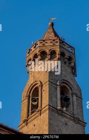 Die Spitze des Glockenturms der Pfarrkirche von San Verano, während die Glocken läuten, vor dem blauen Himmel, Peccioli, Pisa, Italien Stockfoto