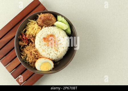 Nasi Uduk, indonesischer Dampfreis, in Kokosmilch gekocht. Serviert mit verschiedenen Beilagen. Das gleiche mit Nasi Lemak Malaysia. Bereich Kopieren Stockfoto