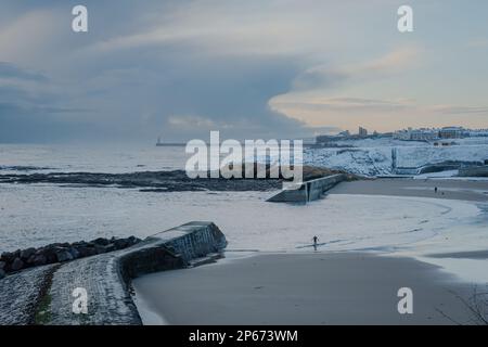 Blick auf Cullercoats Harbour und den schneebedeckten Strand Stockfoto