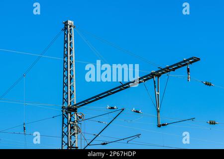 Teil der Kontaktlinie der Eisenbahn. Metallstange und Drähte am blauen Himmel. Stockfoto