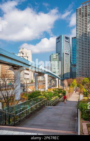 Blick auf die Wolkenkratzer des Viertels Shimbashi und das Viadukt der Yurikamome-Linie vom öffentlichen Park „Parco Italia“ Stockfoto