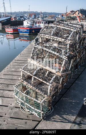 Sehen Sie sich den Hafen von Whitby an, wo Fischereifahrzeuge aneinander hängen und verschiedene dazugehörige Gegenstände auf dem Kai sind. Whitby, Yorkshire Moors National Park. Stockfoto