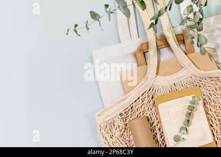 Umweltfreundlicher Einkauf, Lieferservice. Nachhaltiges Stillleben mit Textilbeuteln, Papiertüten, Netzbeuteln, Geschenkpapier auf blauem Hintergrund. Keine Verschwendung, Stockfoto