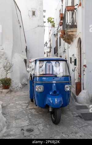 Blaue Tuk-Tuk-Besichtigung durch die engen Gassen der alten weißen Stadt, Ostuni, Provinz Brindisi, Apulien, Italien, Europa Stockfoto