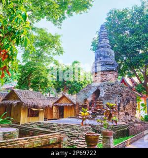 Die Backsteinruinen des antiken Chedi, umgeben von üppigen Bäumen und Bambushütten zur Meditation, Wat Umong Mahathera Chan, Chiang Mai, Thailand Stockfoto