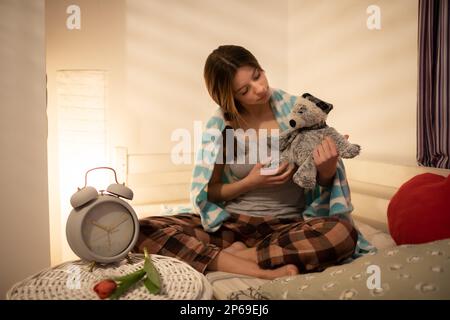 Das Mädchen hält den kuscheligen Teddybär in der Hand. Stockfoto