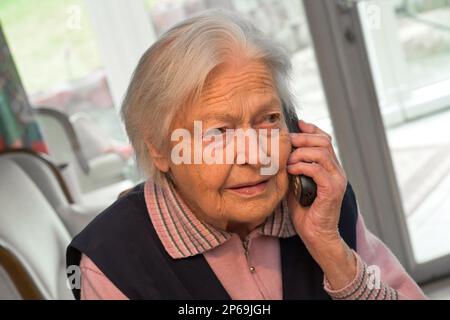 Alte Frau telefoniert - Modell veröffentlicht Stockfoto