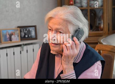 Alte Frau telefoniert - Modell veröffentlicht Stockfoto
