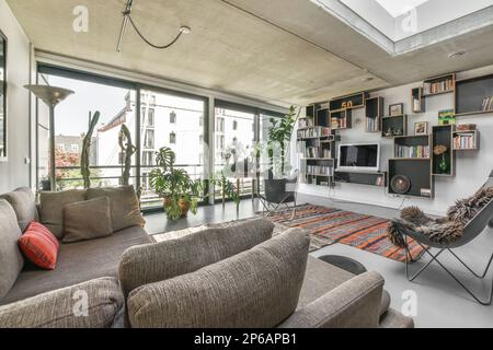 Ein Wohnzimmer mit Sofas, Stühlen und einem Fernseher an der Wand im Zimmer ist sehr groß Stockfoto