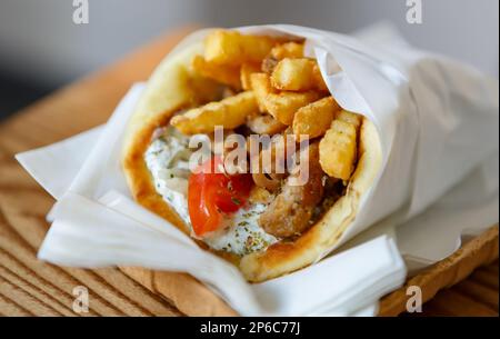 Griechische Gyros zum Mitnehmen im Restaurant. Traditionelles Street Food Gericht aus Griechenland Stockfoto