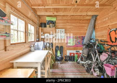 Amsterdam, Niederlande - 10. April 2021: Einige Fahrräder in einem Raum mit holzgetäfelten Wänden und Holzfußboden an der Wand dahinter sind ein Fenster Stockfoto