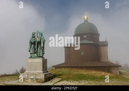 Hölzerne Kapelle und Statue von St. Cyril und Methodius am nebligen Sommertag in den Beskiden in der Tschechischen Republik Stockfoto