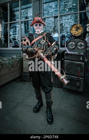 Porträt eines futuristischen Steampunks, der auf der Straße steht und eine Waffe in der Hand hält. Science-Fiction, Retrofuturismus oder Zeitreisekonzept. Stockfoto