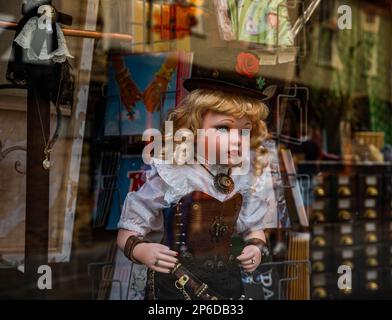 Eine vom Steampunk inspirierte Puppe, die aus einem Schaufenster schaut. Stockfoto