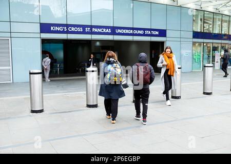 Rückansicht Mutter Teenager Sohn Leute gehen auf der Straße vor den Eingang Kings Cross St Pancras U-Bahnstation London UK KATHY DEWITT Stockfoto