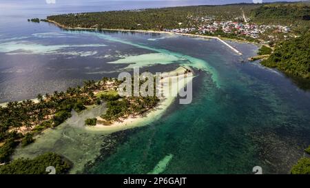 Das Foto bietet einen atemberaubenden Blick auf einen ruhigen Strand mit kristallklarem Wasser und sanften Wellen, die am Ufer schlagen. Stockfoto