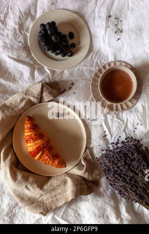 Traditionelles französisches Frühstück mit Croissant, Trauben und heißer Schokolade, Foto über Kopf Stockfoto