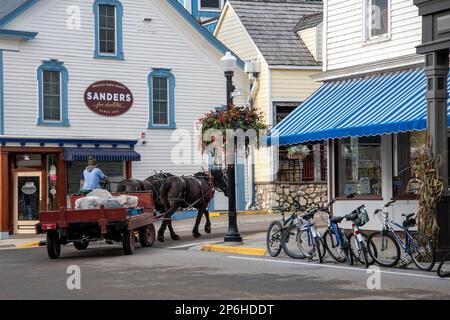 Mackinac Island, Michigan. Auf der Insel sind nur Pferde und Fahrräder erlaubt. Pferdewagen, die Waren an lokale Unternehmen liefern. Stockfoto