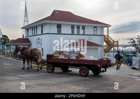 Mackinac Island, Michigan. Auf der Insel sind nur Pferde und Fahrräder erlaubt. Pferdewagen, die Waren an lokale Unternehmen liefern. Stockfoto