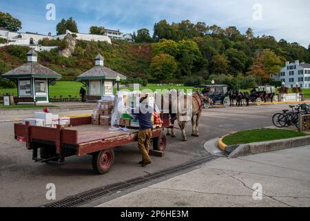 Mackinac Island, Michigan. Auf der Insel sind nur Pferde und Fahrräder erlaubt. Pferdewagen, die Waren an lokale Unternehmen liefern. Stockfoto