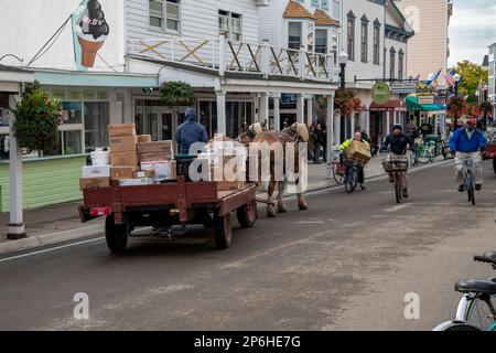 Mackinac Island, Michigan. Auf der Insel sind nur Pferde und Fahrräder erlaubt. Pferdewagen, die Waren an lokale Unternehmen liefern. Stockfoto