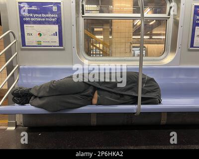 Schlafender Passagier in einem F-Zug nach Manhattan in Brooklyn, New York. Stockfoto
