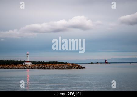 Mackinac Island, Michigan. Das Round Island Passage Light und der Round Island Lighthouse im Hintergrund befinden sich in der Straße von Mackinac und mar Stockfoto