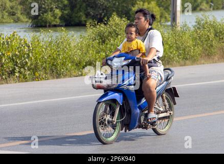 BANGKOK, THAILAND, FEBRUAR 07 2023, Eine Frau fährt mit dem Baby auf einem Motorrad Stockfoto