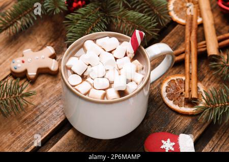 Köstliche heiße Schokolade mit Marshmallows und Weihnachtskeksen auf einem Holztisch Stockfoto