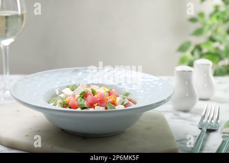 Köstlicher Salat mit Wassermelone, Rucola und Fetakäse, serviert auf einem weißen Marmortisch Stockfoto