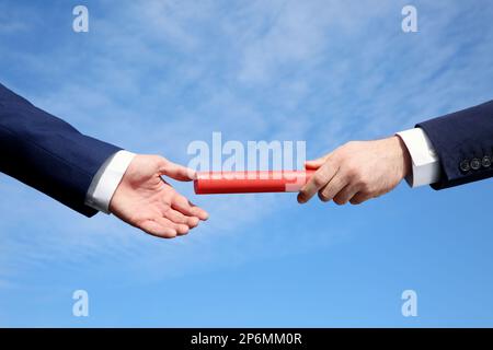 Ein Geschäftsmann, der seinen Partner gegen den blauen Himmel anspricht. Nahaufnahme Stockfoto