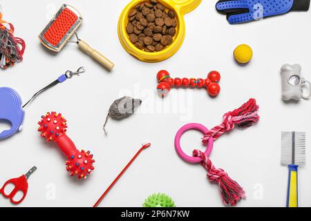 Set aus Tierpflegezubehör, Spielzeug und Trockenfutter auf hellem Hintergrund Stockfoto