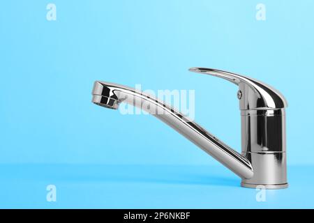 Wasserhahn mit einem Griff auf hellblauem Hintergrund Stockfoto