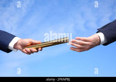 Ein Geschäftsmann, der seinen Partner gegen den blauen Himmel anspricht. Nahaufnahme Stockfoto