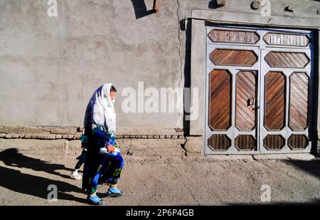 Eine usbekische Frau, die in der Altstadt von Bukhara, Usbekistan, spaziert. Stockfoto