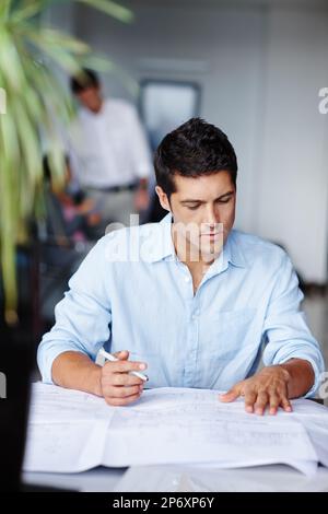 Architektur ist seine Leidenschaft. Ein talentierter junger Architekt, der an seinen Bauplänen arbeitet. Stockfoto