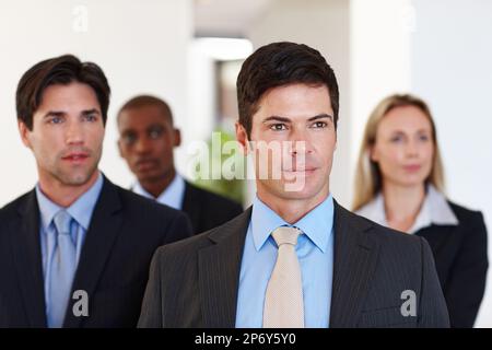 Mit Blick in die Zukunft. Vielfältige Gruppe von Geschäftsleuten, die drinnen stehen. Stockfoto