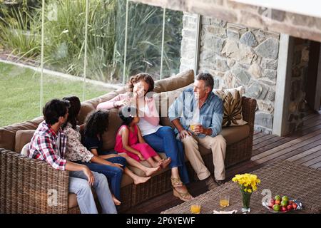 Die Familie einholen. Eine Familie der 3. Generation, die sich zu Hause entspannen kann. Stockfoto
