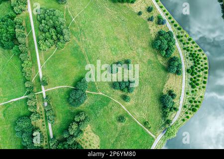 Spazierwege am Fluss im Sommerpark. Luftaufnahme mit Drohne. Stockfoto