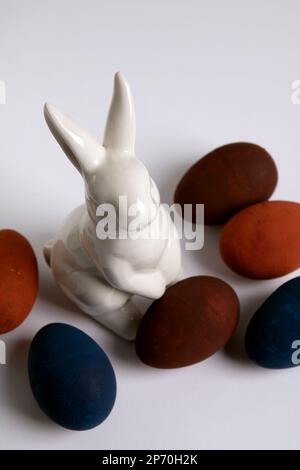 Foto: Dekoratives Ei und weißes Kaninchen in verschiedenen Farben auf weißem Hintergrund Stockfoto