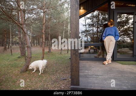 Die Frau ruht in der Nähe einer hölzernen Hütte in der Natur Stockfoto