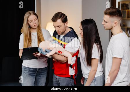 Gruppe von Personen, die während des Trainings im Innenbereich erste Hilfe mit dem Blindkind leisten lernen. Stockfoto