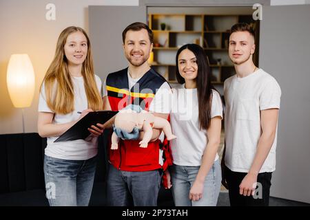 Gruppe von Personen, die während des Trainings im Innenbereich erste Hilfe mit dem Blindkind leisten lernen. Stockfoto