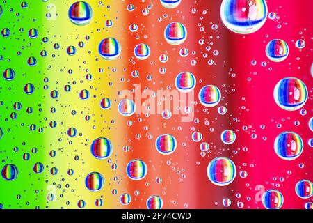 Farbenfroher abstrakter Hintergrund mit Wassertropfen auf Glas in Regenbogenfarben Stockfoto