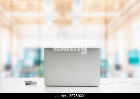 Rückseite des modernen Laptops auf dem Bürotisch mit Maus. Stockfoto