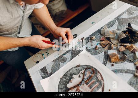 Handwerker Schneiden von Smaltglas mit Zangen Cutter für die Herstellung von Smaltglas Mosaik Stockfoto